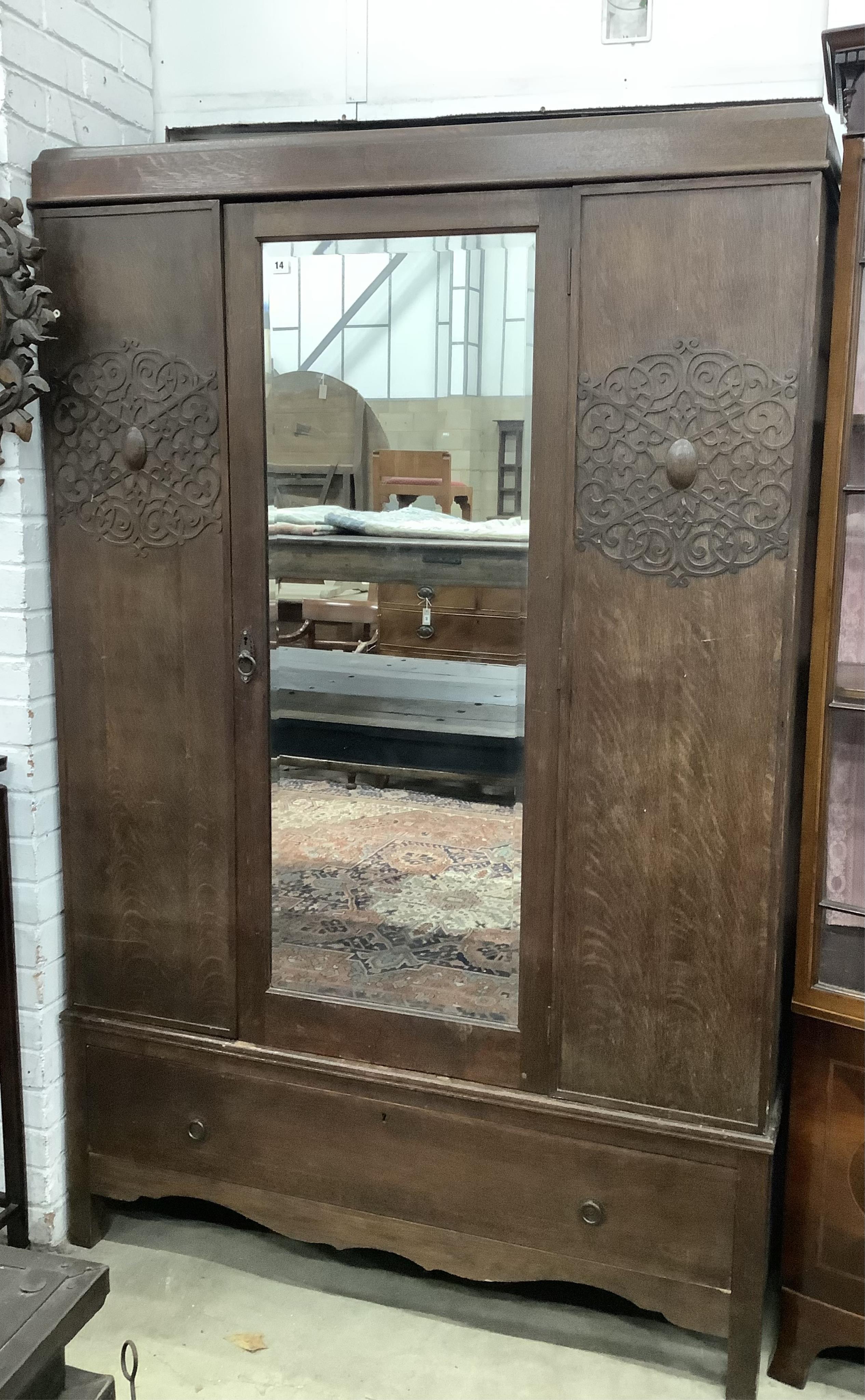 An early 20th century oak mirrored wardrobe, width 124cm, depth 42cm, height 188cm. Condition - good